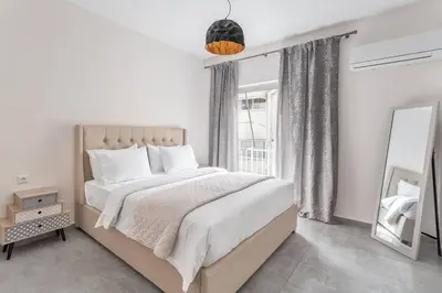 a bedroom with a large bed and a large window at Afroditi Suite in Athens