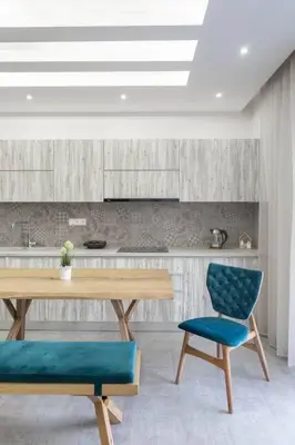 a kitchen with a wooden table and two blue chairs at Afroditi Suite in Athens