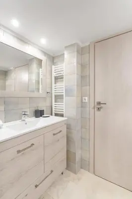 a white bathroom with a sink and a mirror at Afroditi Suite in Athens