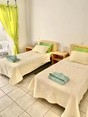 a room with three beds with towels on them at 2 Bedroom, Sea Side Retreat Saronida in Saronida