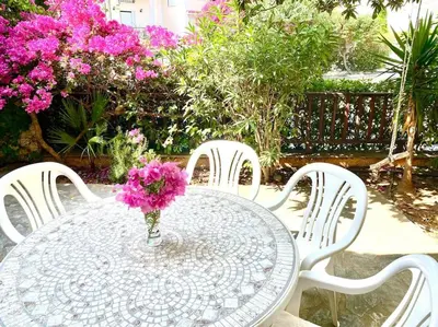 a table with a vase of pink flowers on it at 2 Bedroom, Sea Side Retreat Saronida in Saronida