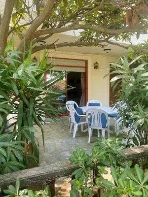 a patio with a table and chairs in a yard at 2 Bedroom, Sea Side Retreat Saronida in Saronida