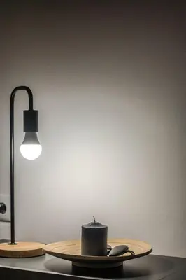 a table with a candle on a plate next to a lamp at Minimalistic! in Athens