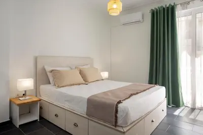 a bedroom with a large bed with a green curtain at Silk Mill Metaxourgeio, Athens Centre in Athens