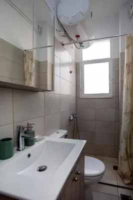 a bathroom with a white sink and a toilet at Silk Mill Metaxourgeio, Athens Centre in Athens