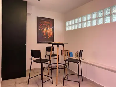 a room with three bar stools and a painting on the wall at Silk Mill Metaxourgeio, Athens Centre in Athens
