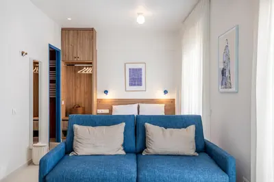 a blue couch with two white pillows in a room at Kallithea Apartments by Olala Homes in Athens