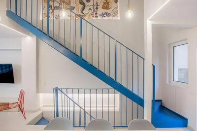 a blue staircase in a white room with chairs at Kallithea Apartments by Olala Homes in Athens