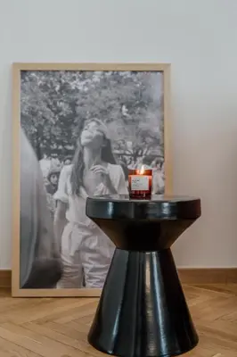 a candle on a stand in front of a painting at Bella in Athens