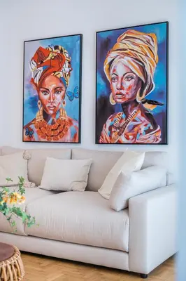 two paintings on a wall above a white couch at Zelda in Athens