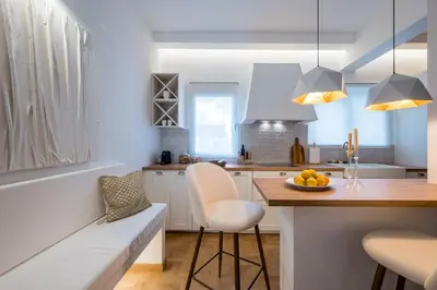 a kitchen with white cabinets and a table with a bowl of fruit at Zelda in Athens