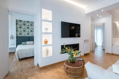 a living room with a bed and a tv on a wall at Zelda in Athens