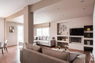 a living room with a couch and a tv at Glyfada Premium Residence in Athens