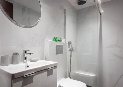 a white bathroom with a toilet and a shower at Glyfada Premium Residence in Athens