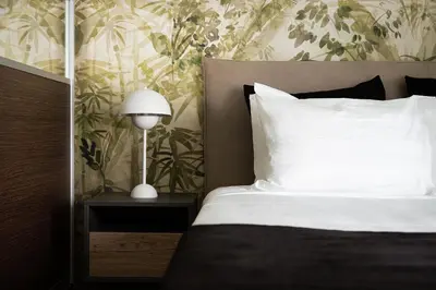 a bedroom with a bed with white sheets and a lamp at Glyfada Premium Residence in Athens
