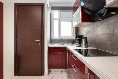 a kitchen with red cabinets and a wooden door at Glyfada Premium Residence in Athens