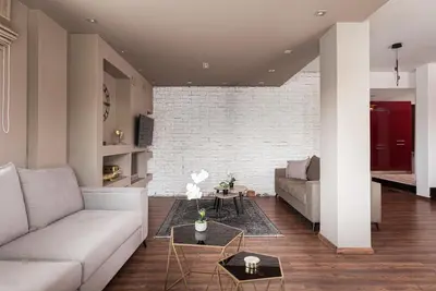 a living room with a couch and a brick wall at Glyfada Premium Residence in Athens