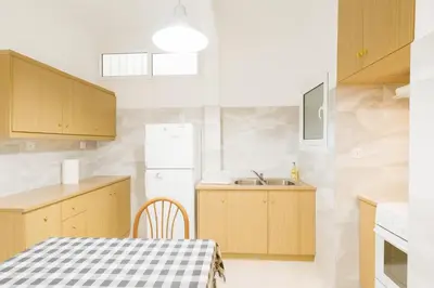 a kitchen with a table and a white refrigerator at Sunny Dream House in Piraeus