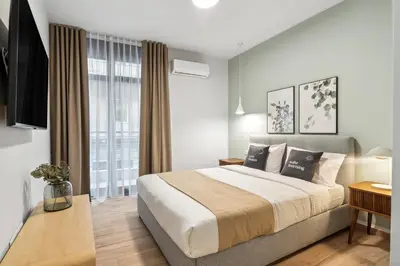 a bedroom with a large bed and a large window at Limehome Athens Solonos City Center in Athens