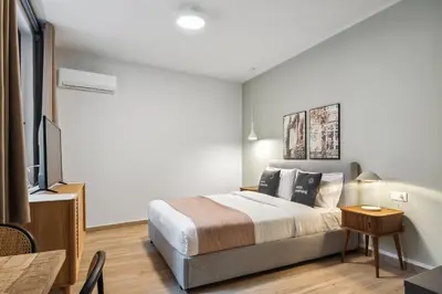 a bedroom with a king sized bed and a television at Limehome Athens Solonos City Center in Athens