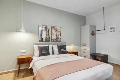 a bedroom with a large bed with two pictures on the wall at Limehome Athens Solonos City Center in Athens