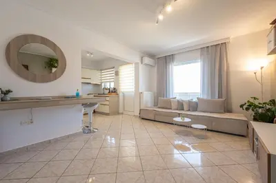 a large living room with a couch and a table at Nesto Athens Airport Den in Spáta