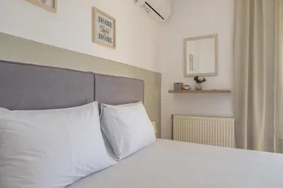 a bedroom with a bed with white pillows at Nesto Athens Airport Den in Spáta