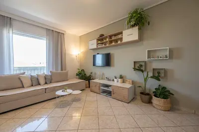 a living room with a couch and a tv at Nesto Athens Airport Den in Spáta