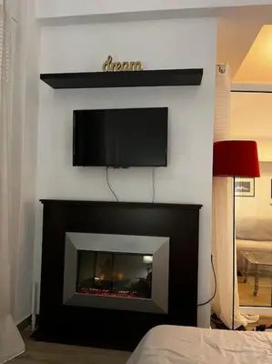 a living room with a fireplace with a tv above it at Athena 1 in Athens