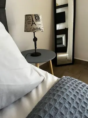 a lamp sitting on a table next to a bed at Athena 1 in Athens