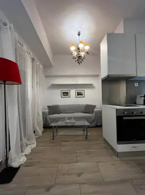 a kitchen with a couch and a chandelier in a room at Athena 1 in Athens