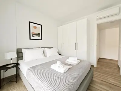 a white bedroom with a bed with towels on it at Kapodistriou by Verde Apartments in Athens