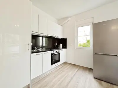 a kitchen with white cabinets and a stainless steel refrigerator at Kapodistriou by Verde Apartments in Athens