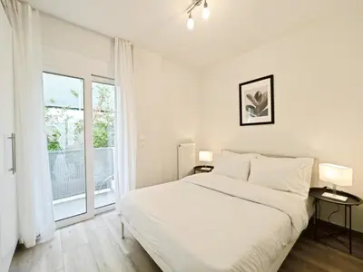 a white bedroom with a large bed and a window at Kapodistriou by Verde Apartments in Athens