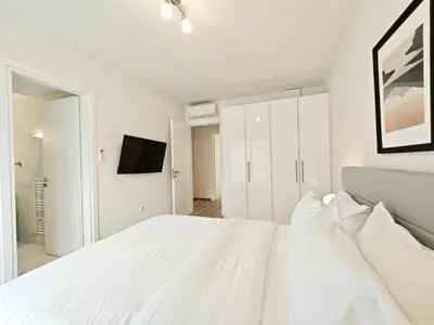 a white bedroom with a white bed and a tv at Kapodistriou by Verde Apartments in Athens