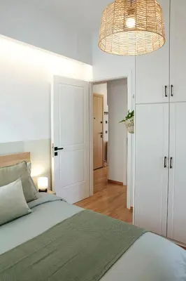 a bedroom with a bed and a chandelier at MINT - Modern apartment in the heart of Chalandri in Athens