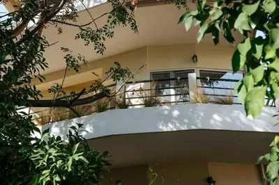a balcony of a building with trees in the foreground at MINT - Modern apartment in the heart of Chalandri in Athens