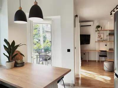 a kitchen and living room with a table and a dining room at MINT - Modern apartment in the heart of Chalandri in Athens