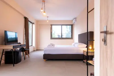 a bedroom with a bed and a television at Mini Suites Near Athen's Airport Free Shuttle From and to Athen's Airport in Spáta