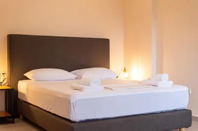 a bedroom with a large bed with towels on it at Mini Suites Near Athen's Airport Free Shuttle From and to Athen's Airport in Spáta