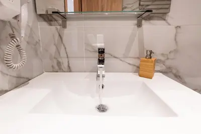 a bathroom with a sink with a faucet at Mini Suites Near Athen's Airport Free Shuttle From and to Athen's Airport in Spáta