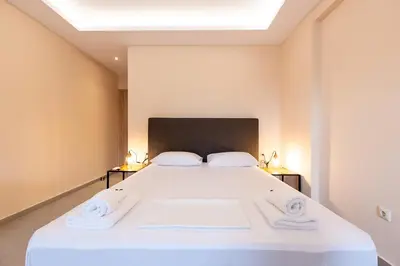 a bedroom with a large white bed with two pillows at Mini Suites Near Athen's Airport Free Shuttle From and to Athen's Airport in Spáta