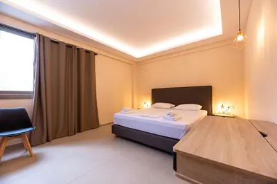 a bedroom with a bed and a chair and a window at Mini Suites Near Athen's Airport Free Shuttle From and to Athen's Airport in Spáta