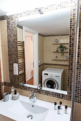 a bathroom with a sink and a washing machine at Ruby’s House in Athens