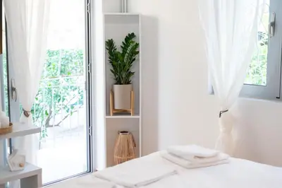 a white room with a window and a plant at Ruby’s House in Athens
