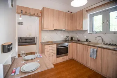 a kitchen with wooden cabinets and a table with wine glasses at Ruby’s House in Athens