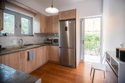 a kitchen with a stainless steel refrigerator and wooden cabinets at Ruby’s House in Athens