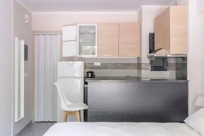 a kitchen with a white chair and a refrigerator at Voula's Secret Garden Studio in Athens
