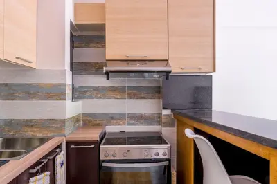 a small kitchen with a stove and a sink at Voula's Secret Garden Studio in Athens