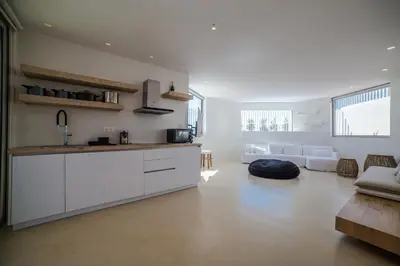 a kitchen with white cabinets and a living room at Seafront Athens Riviera Lagonisi Villa in Lagonissi